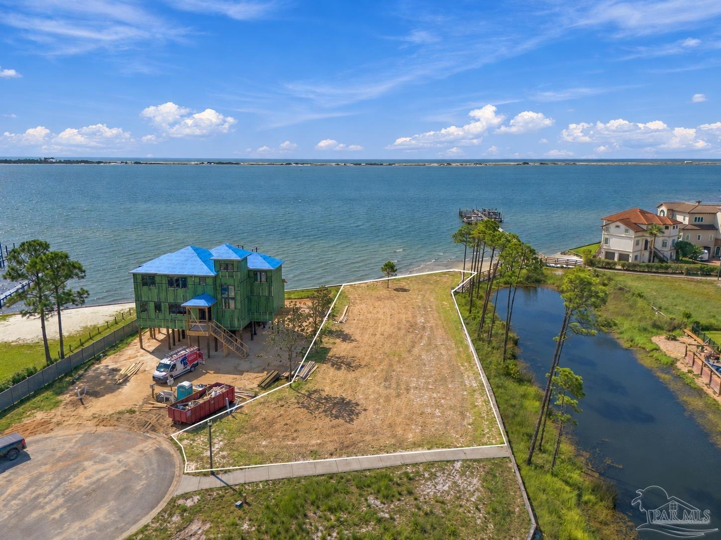 Aerial view of a cleared waterfront lot outlined in white beside the bay.