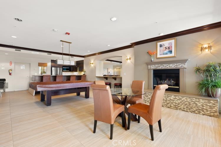 Furnished recreation room with a pool table, fireplace, and dining area.