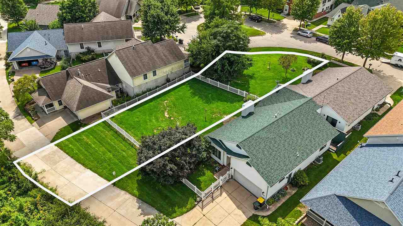 Aerial view of a house and fenced yard, with the property boundary outlined in white.