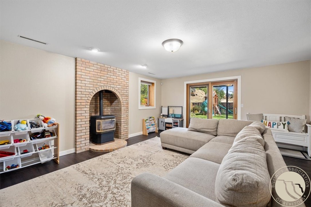 Living room with a brick fireplace, large sectional sofa, and sliding doors overlooking the backyard.