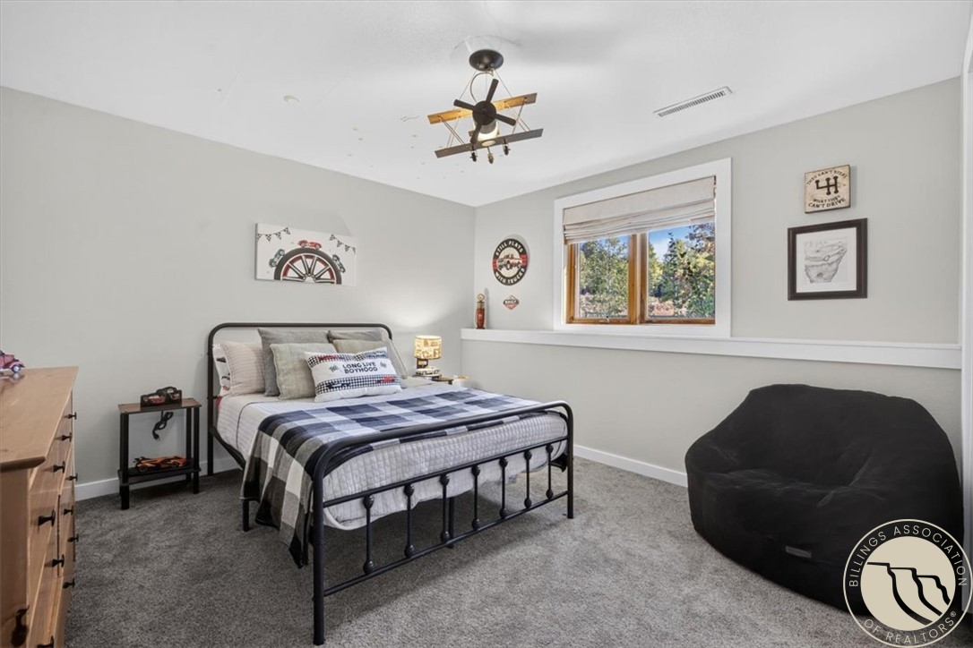 Furnished bedroom with a black metal bed, checkered bedding, and a large black beanbag chair.