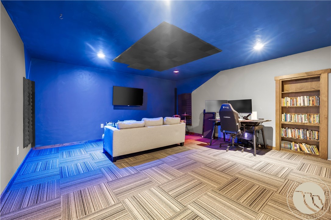 Entertainment room with blue walls, a sofa, desk setup, and built-in bookcase.