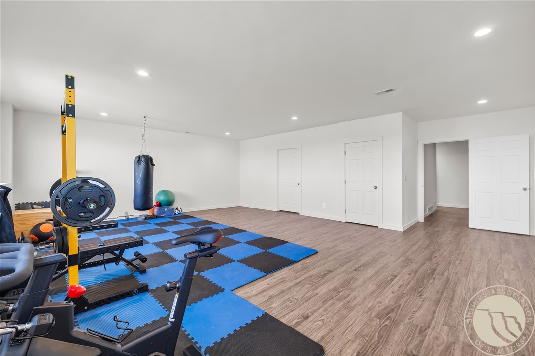 Home gym with weight equipment, a punching bag, and blue-and-black exercise mats.