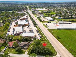 Aerial view of a location marked by a red star beside FM 517, near homes and businesses.