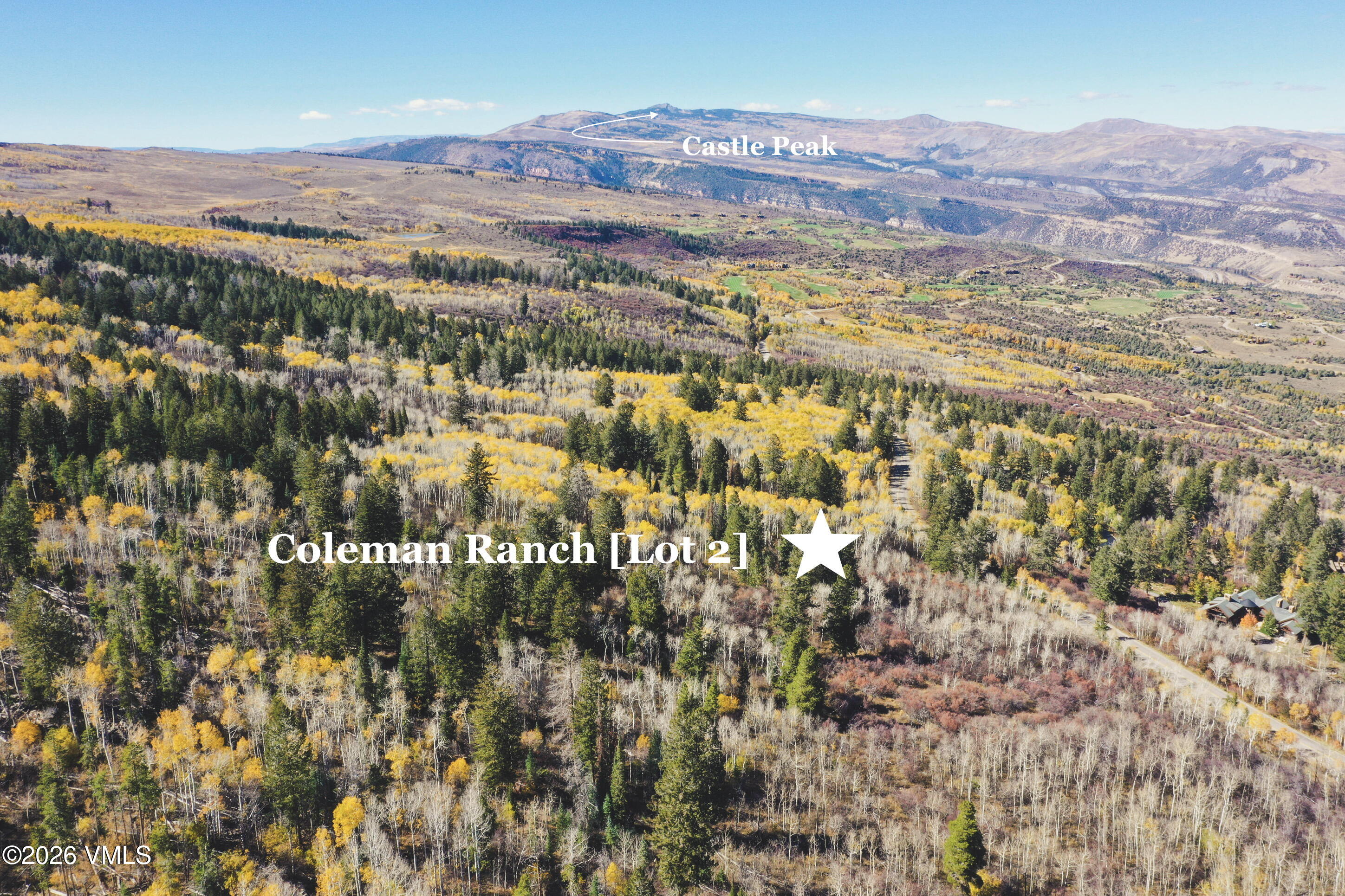 Aerial view of wooded Coleman Ranch Lot 2, with golden aspens and Castle Peak in the distance.