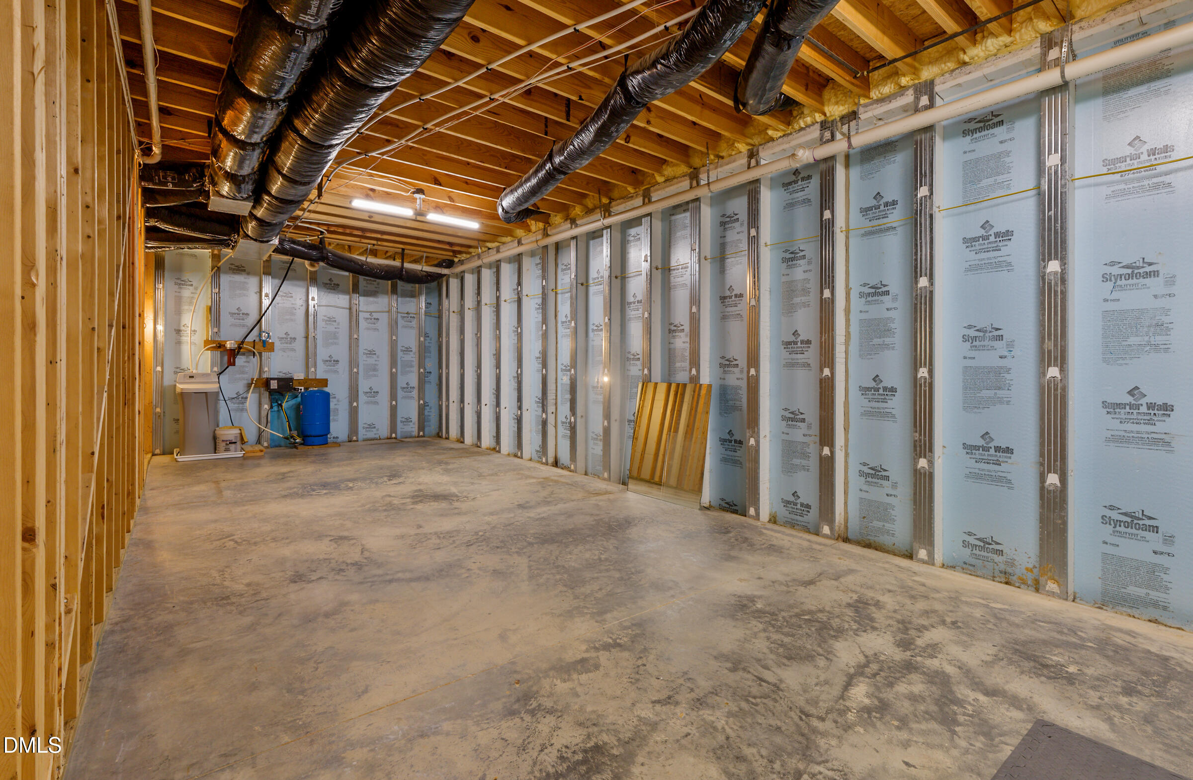 Unfinished basement with exposed ceiling joists, insulated walls, and utility equipment.