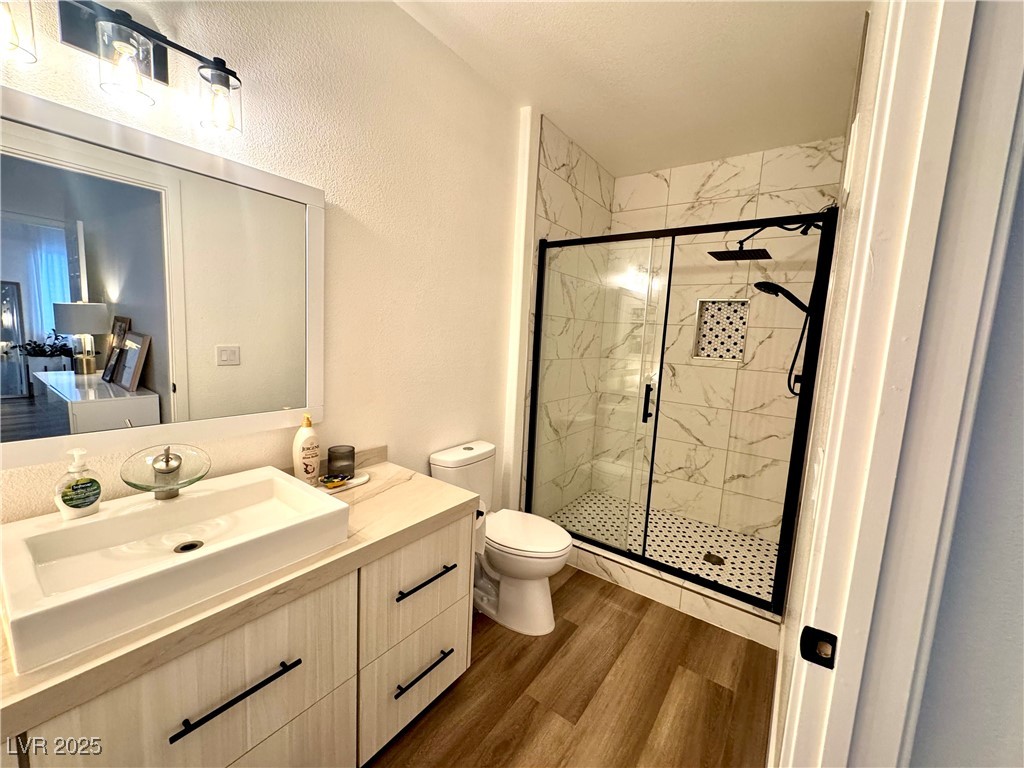 Bathroom with a white vanity and black-framed glass shower featuring marble-look tile.