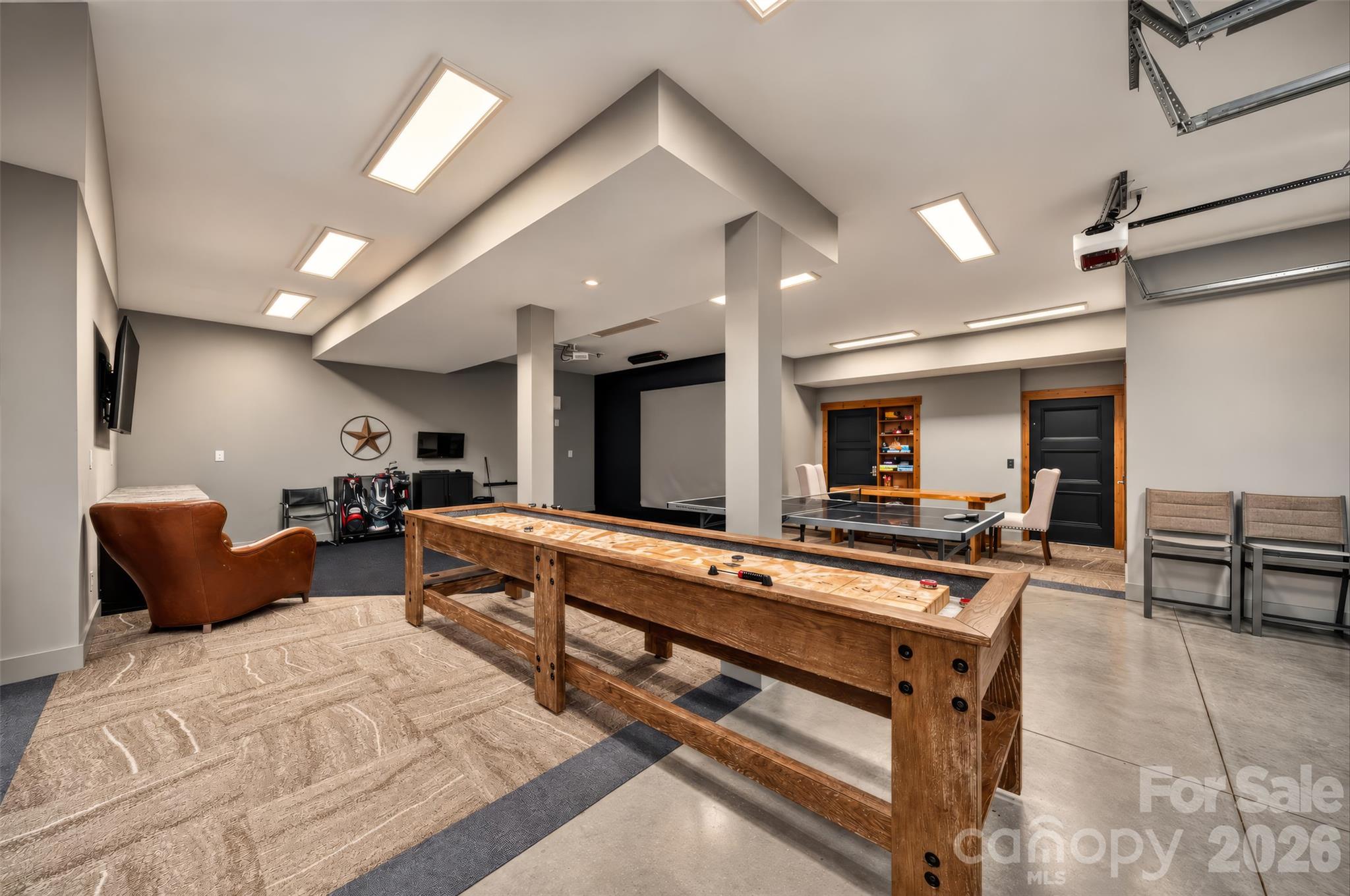 Recreation room with a wooden shuffleboard table, ping-pong table, and golf clubs.
