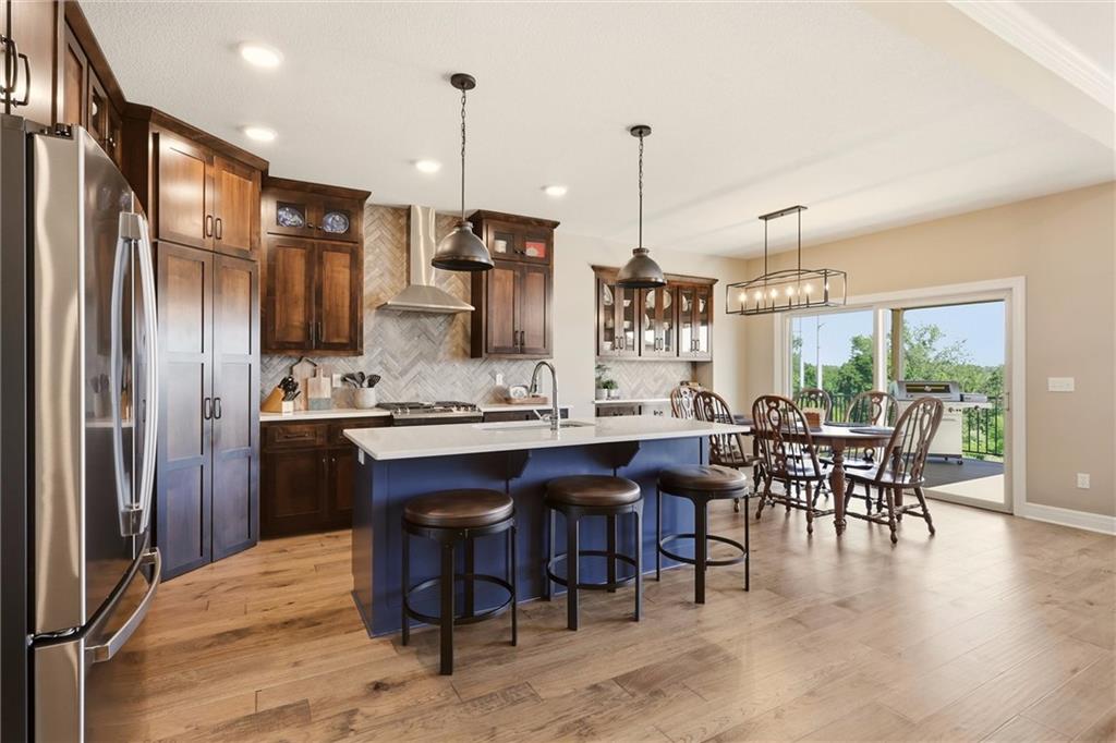 Kitchen with a blue island, dark wood cabinetry, and dining area beside sliding glass doors.