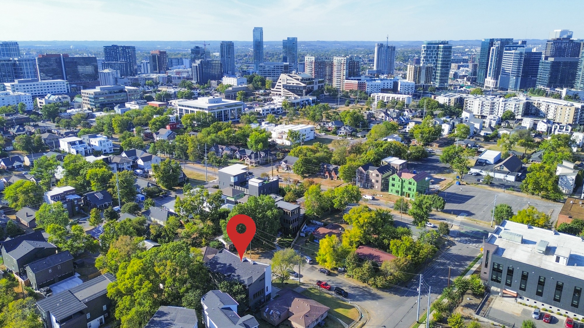 Aerial view of a leafy Nashville neighborhood and downtown skyline, with a red pin marking the property.