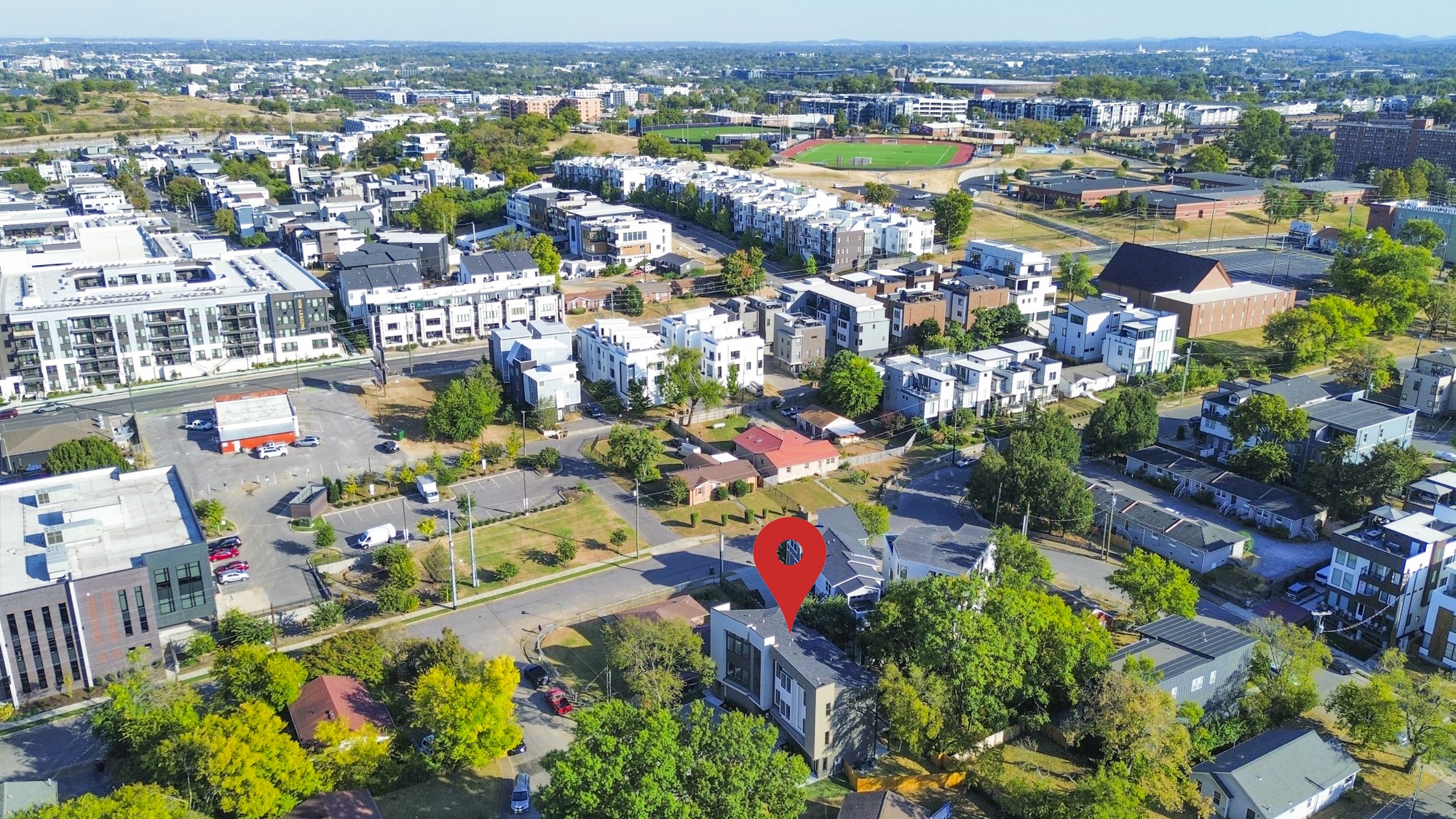Aerial view of a residential neighborhood, with a red marker identifying the property.