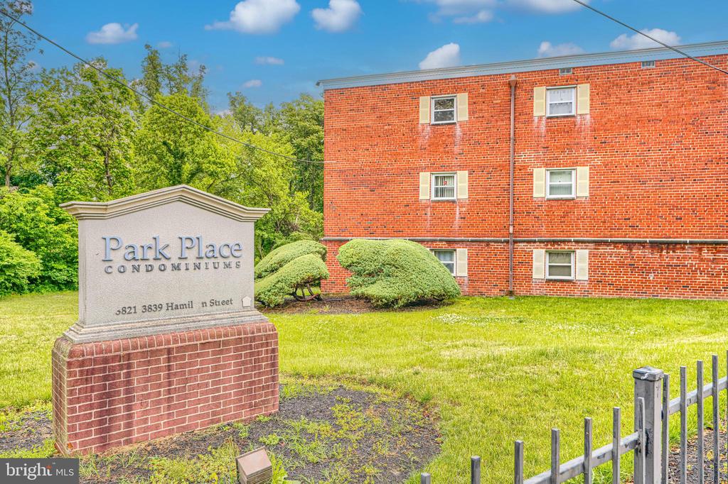 Park Place condominium building beside its brick monument sign and landscaped lawn.