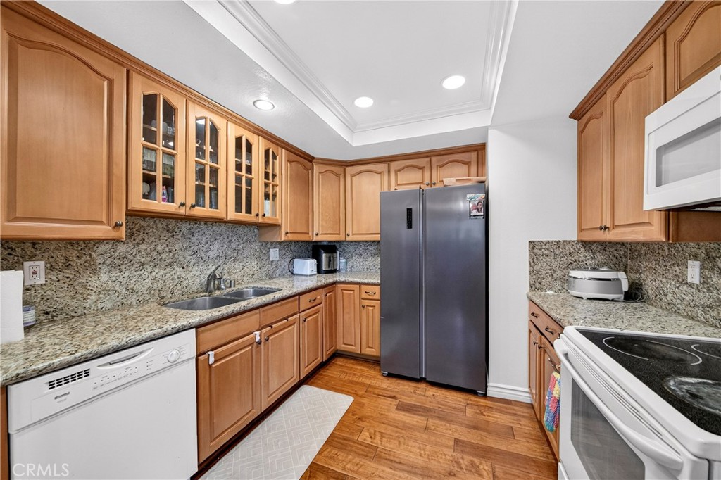 Kitchen with wood cabinetry, granite counters, and a dark gray refrigerator.