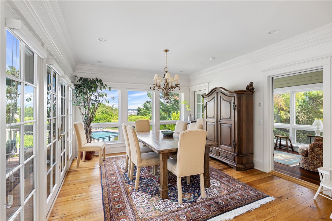 Dining room with a wooden table, large windows, and a view of the pool.