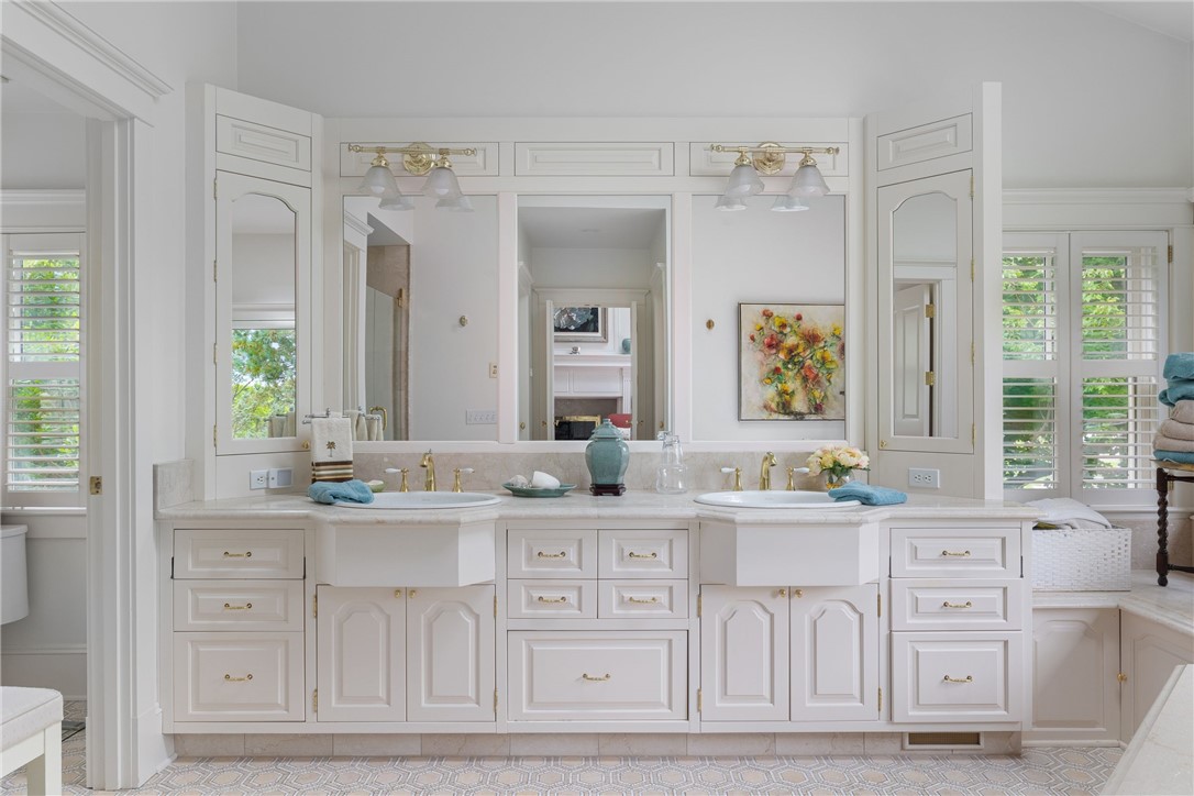 Bright bathroom with a white double vanity, twin sinks, and large mirrors.