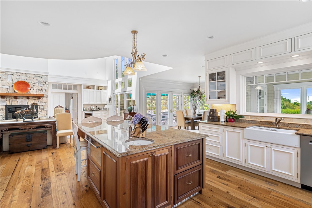 Bright kitchen with a large wood-paneled island, white cabinetry, and hardwood floors.