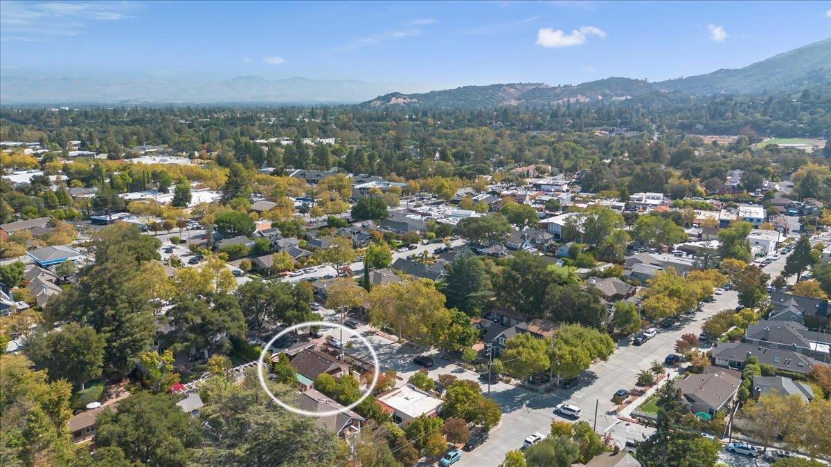 Aerial view of a Los Gatos neighborhood, with the property circled and wooded hills beyond.