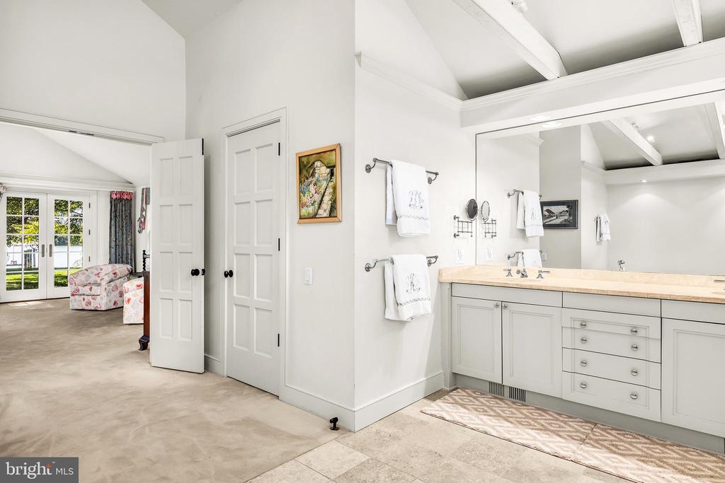 Bathroom with a long double-sink vanity and an adjoining sitting area with French doors.