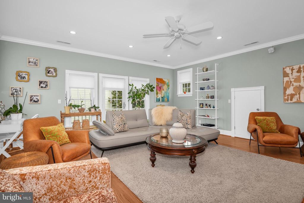 Living room with a gray sofa, rust-colored armchairs, and a glass-topped coffee table.