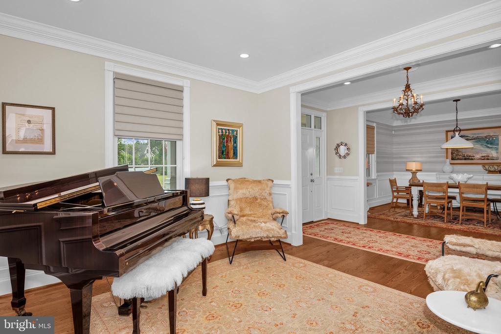 Living room with a grand piano and a wide opening to the dining room.