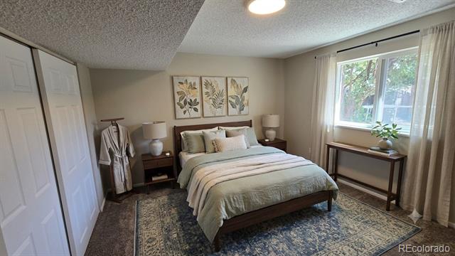 Bedroom with a large bed, botanical wall prints, and a bright curtained window.
