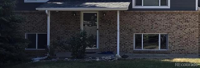 Brick-front home with dark blue upper siding and a recessed front entry.