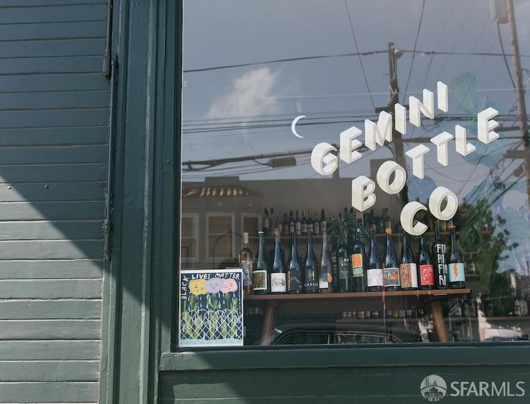 Gemini Bottle Co storefront with bottles displayed behind the window and a Black Lives Matter poster.