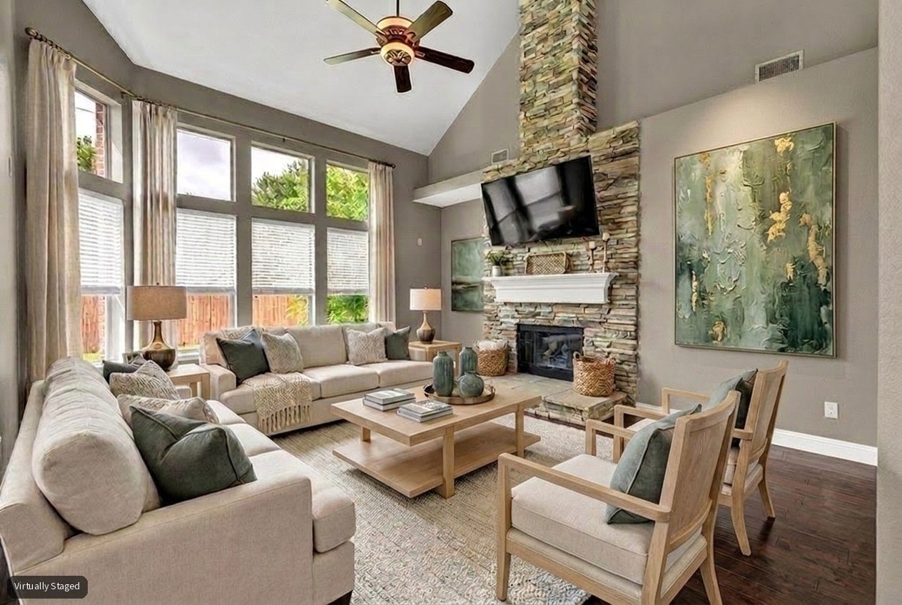 Virtually staged living room with tall windows, a vaulted ceiling, and a stone fireplace.