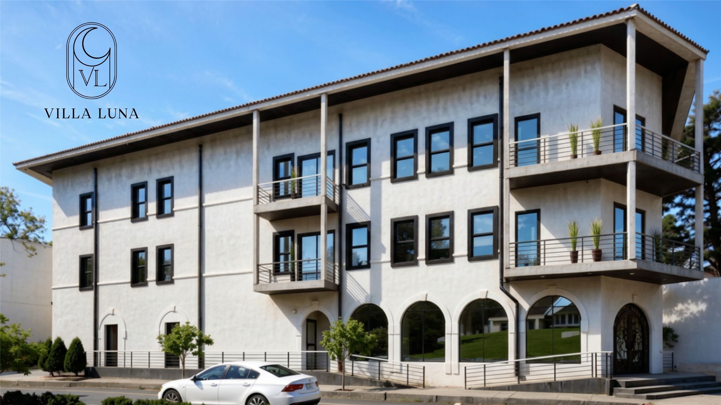 Modern white building with black-framed windows, balconies, and arched ground-floor windows.