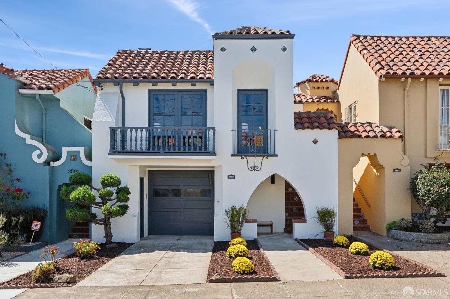 White stucco home at 2587 26th Avenue with a tiled roof, balcony, and arched entry.