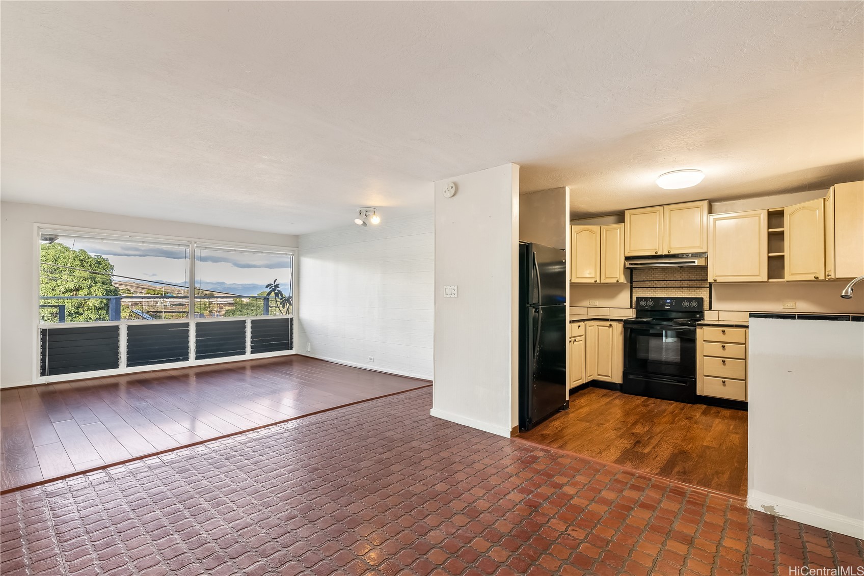 Open living room and kitchen with large windows overlooking distant mountains.