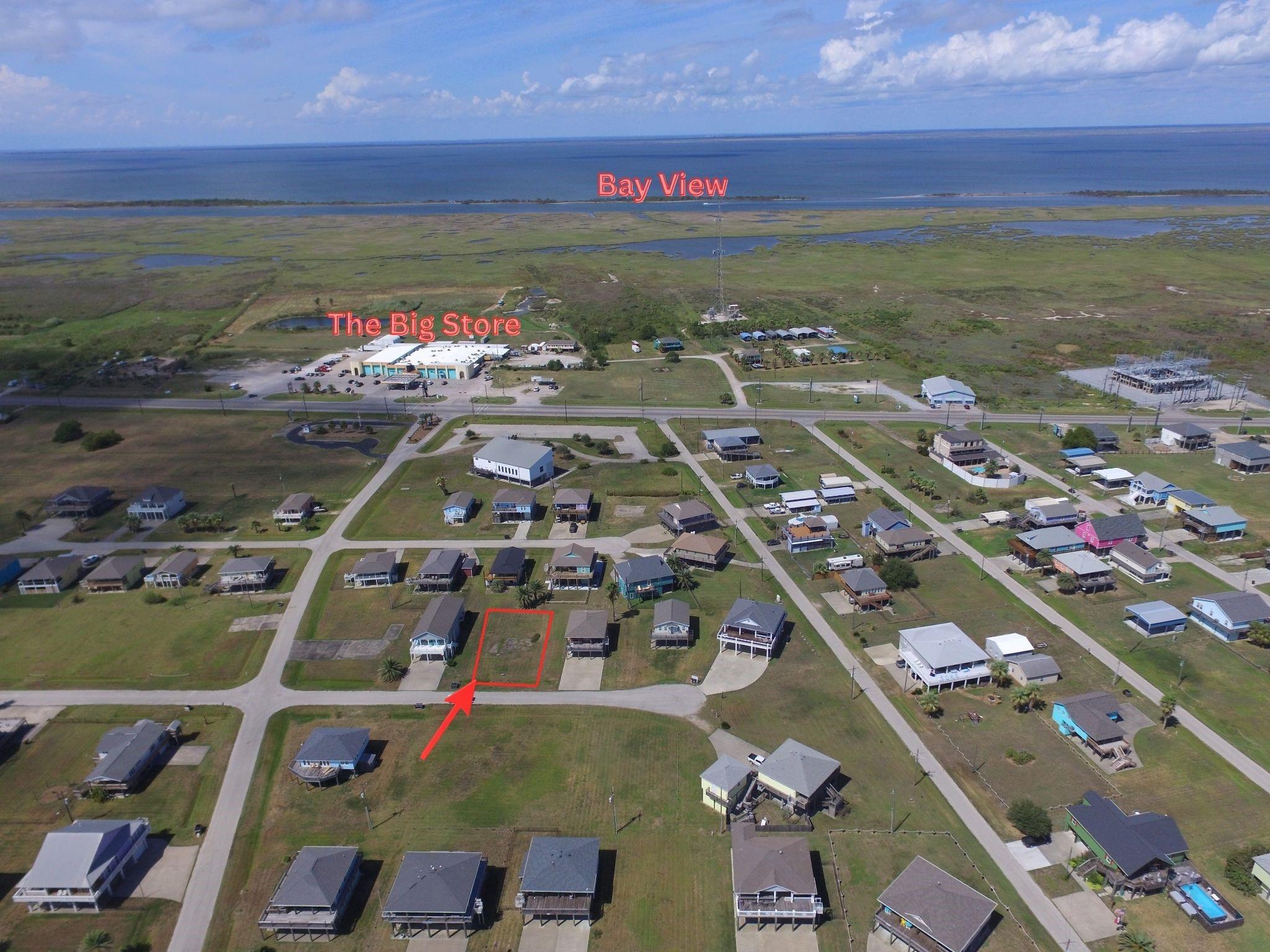 Aerial view of the vacant lot outlined in red, with the bay beyond the neighborhood.