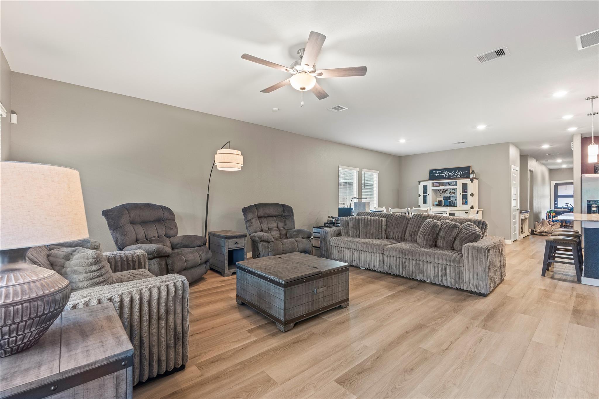 Furnished living room with gray seating, a dark wood coffee table, and light wood floors.