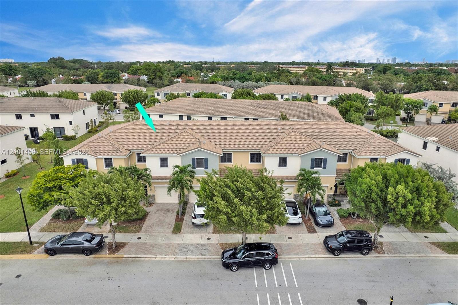 Aerial view of a townhouse marked by a turquoise arrow among neighboring homes.