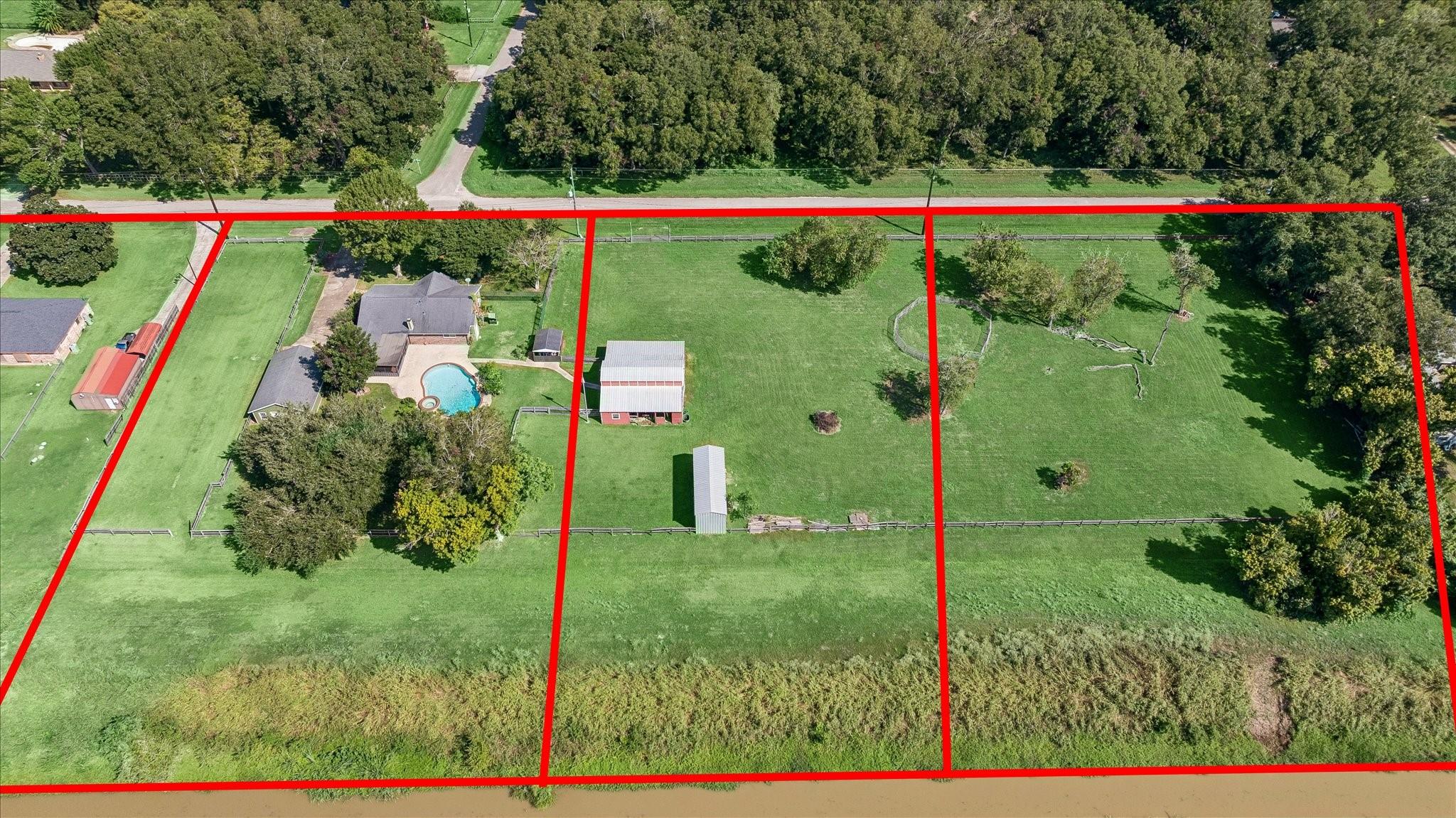 Aerial view of a rural property outlined in red, with a home, pool, barns, and fenced pasture.