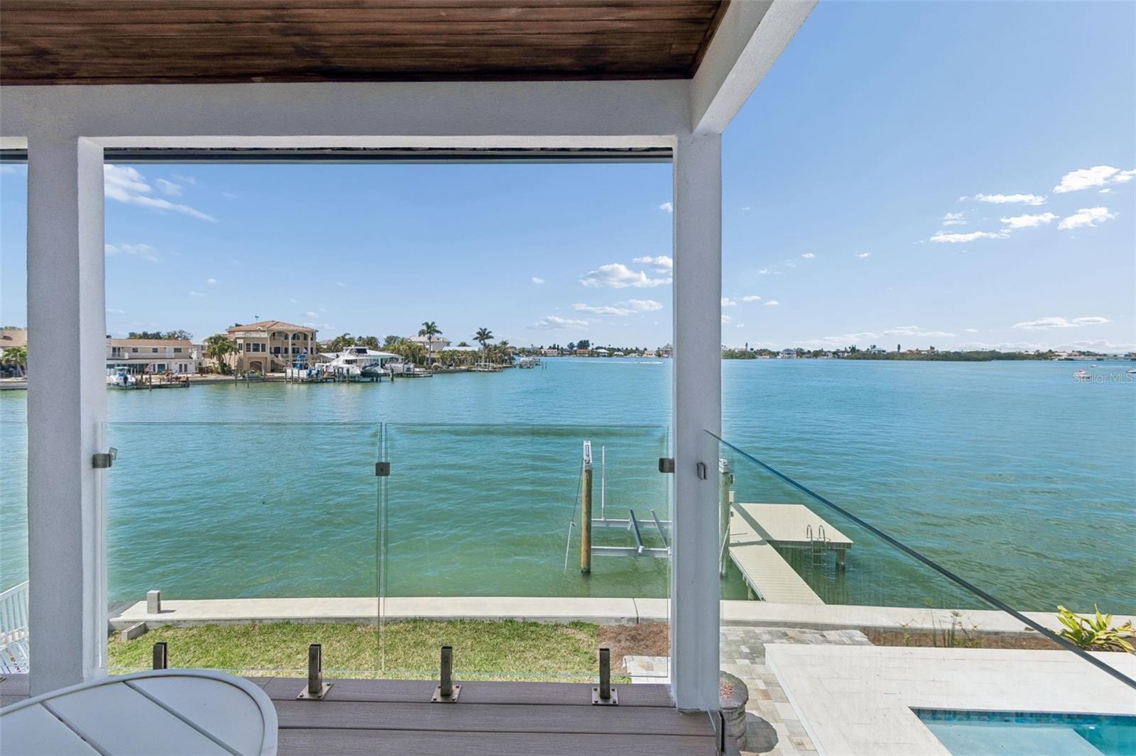 Covered patio overlooking waterfront homes, docks, and a swimming pool.