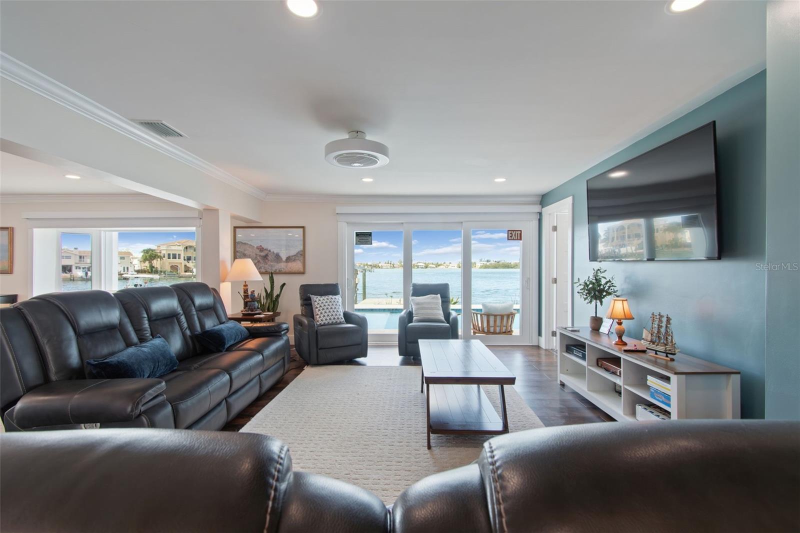 Living room with leather seating and sliding doors overlooking the water.
