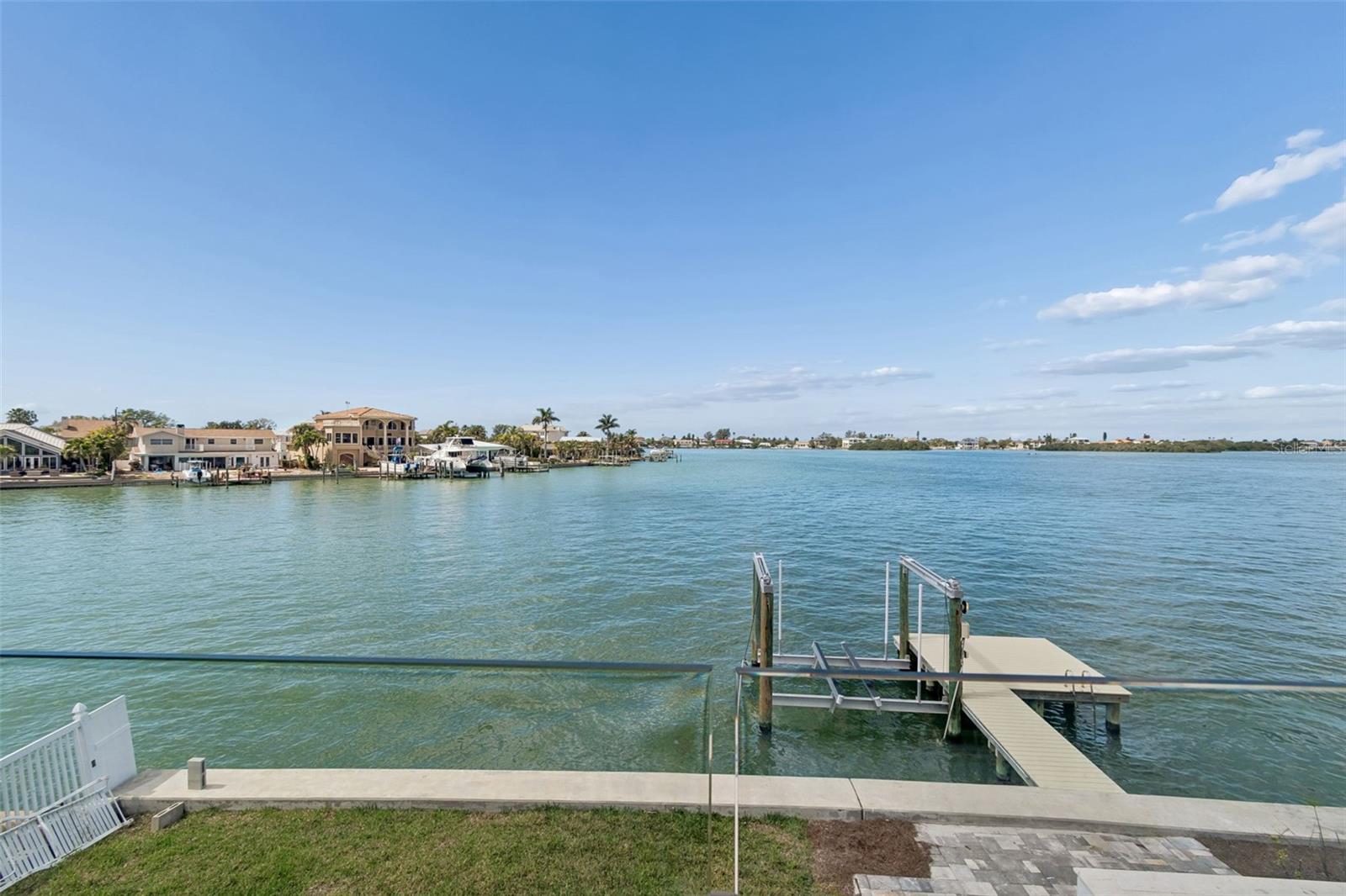 Waterfront view from the yard, with a private dock and homes across the water.