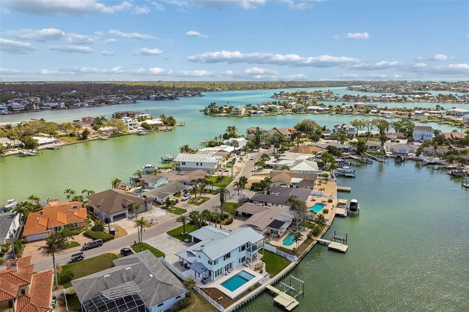 Waterfront home with a swimming pool, private dock, and wide waterway views.