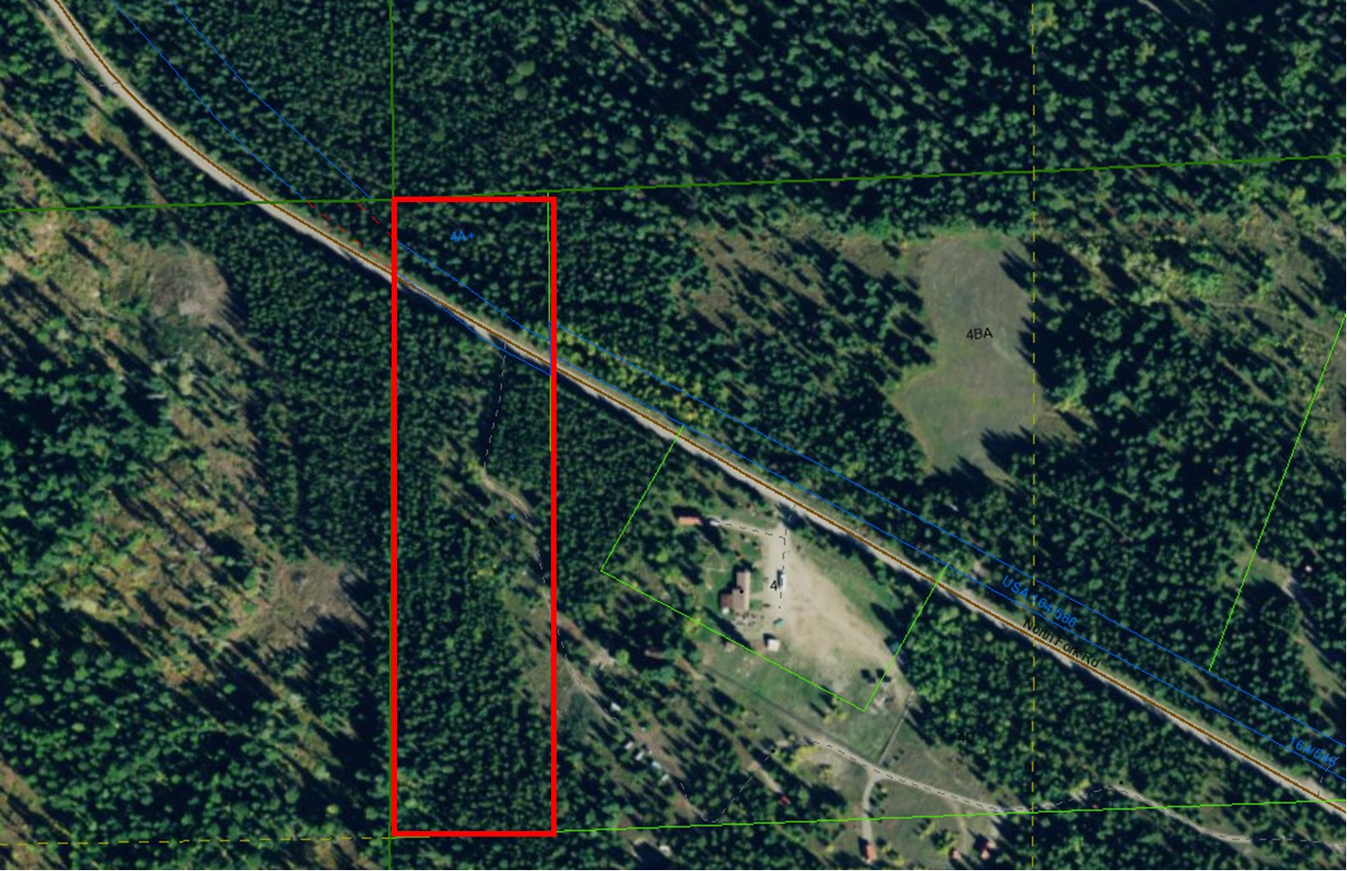Aerial view of a forested parcel outlined in red beside North Fork Road.