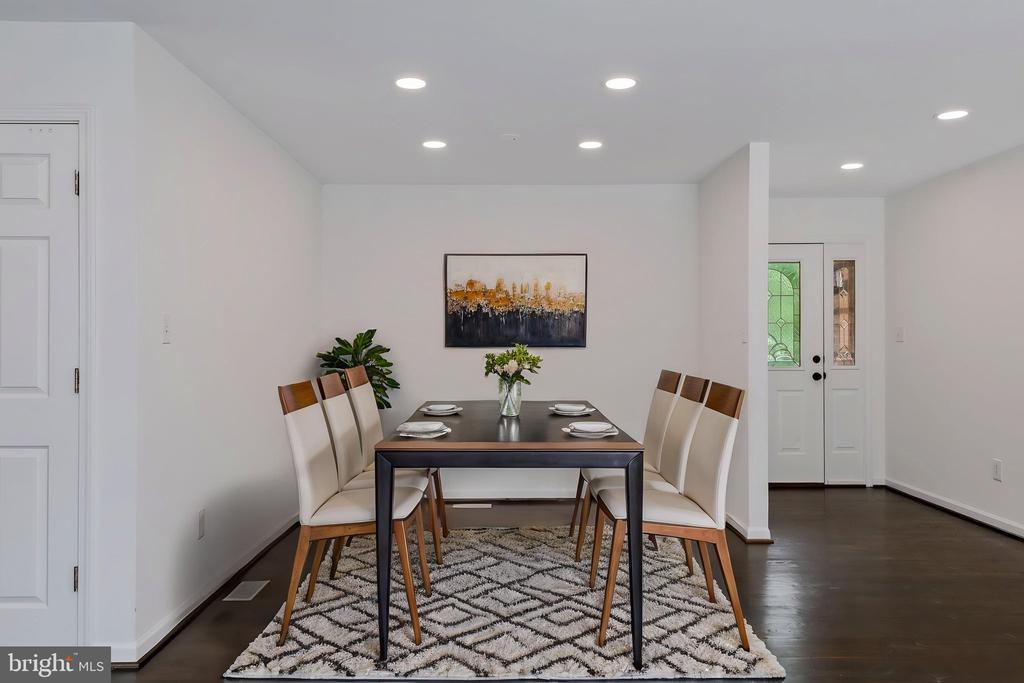 Dining room with a dark table, upholstered chairs, and a geometric rug.