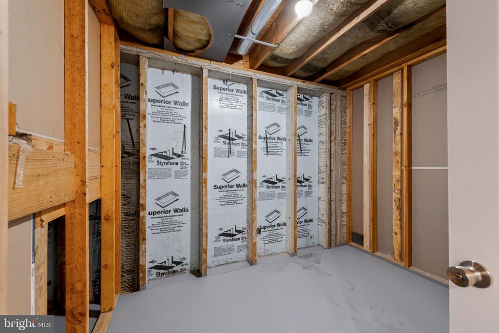 Unfinished room with exposed wooden framing, ceiling insulation, and white wall insulation panels.