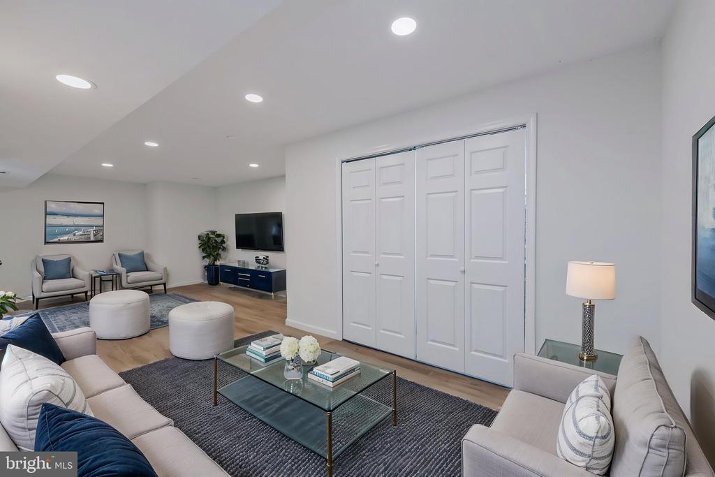 Living room with pale sofas, a glass coffee table, and white paneled double doors.