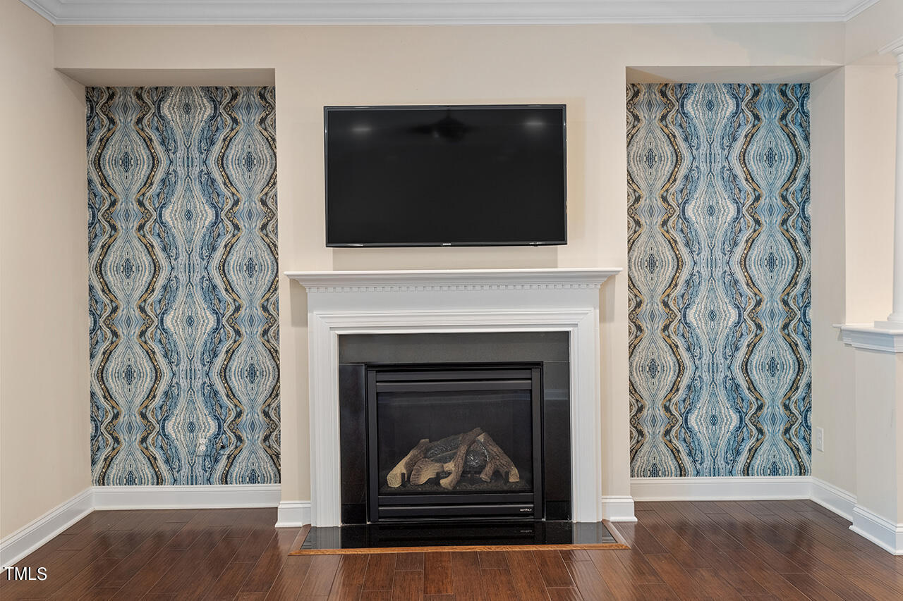 Living room fireplace with a mounted television and blue patterned wall panels.