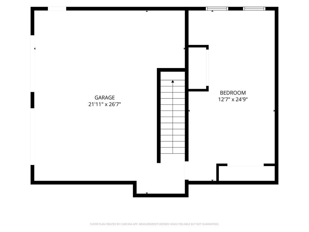 Floor plan with a large garage, staircase, and bedroom labeled with dimensions.