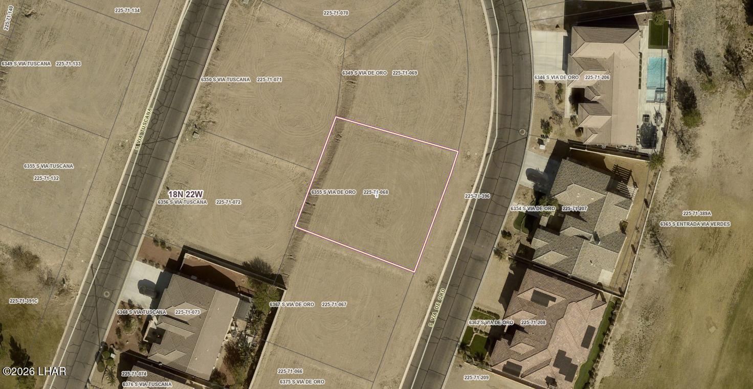 Aerial view of vacant 6355 S Via De Oro lot outlined in pink among nearby homes.