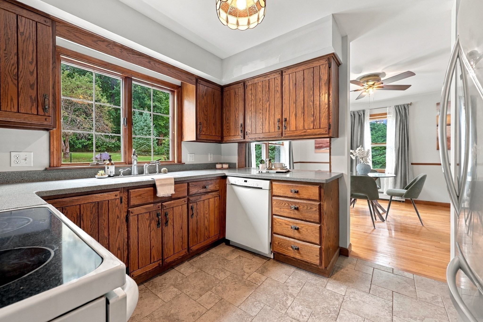 Kitchen with warm wood cabinets, a window above the sink, and an adjoining dining area.