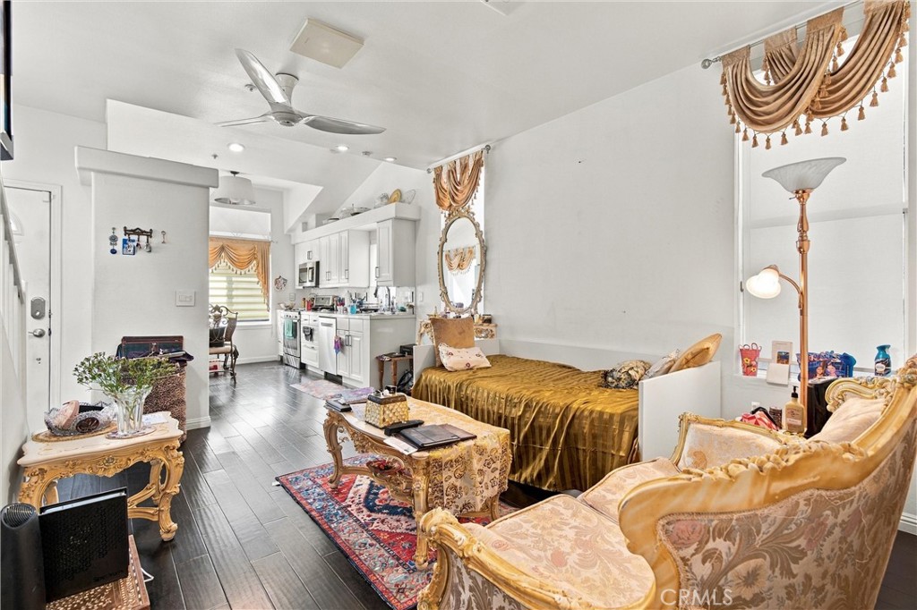Furnished studio living area with a bed, ornate seating, and compact kitchen.