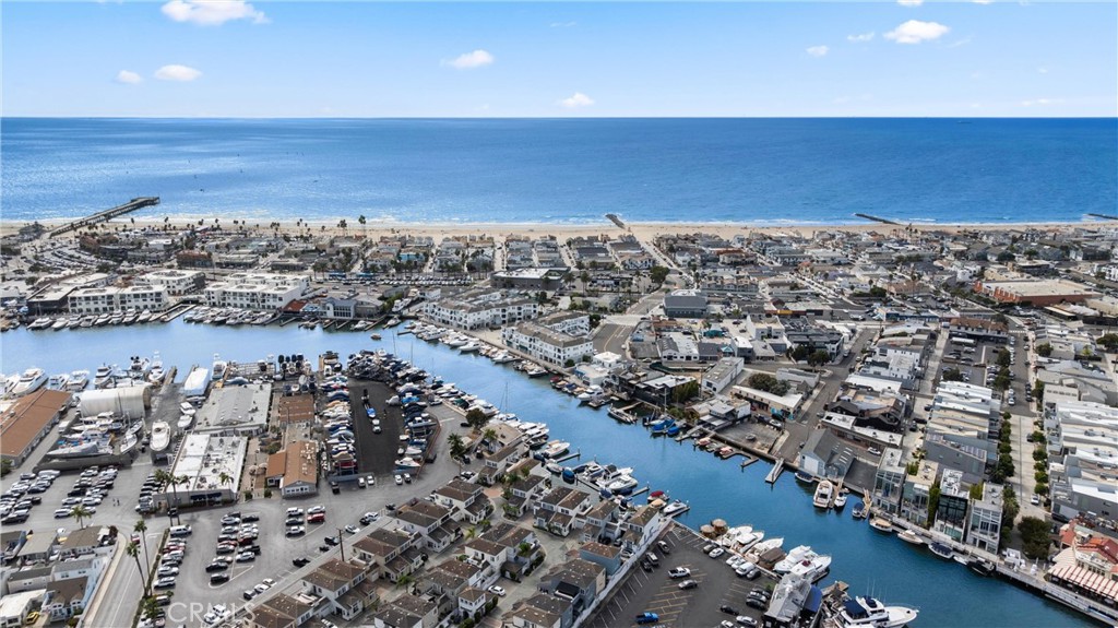 Aerial view of Newport Beach marina, harbor channels, and oceanfront beach.