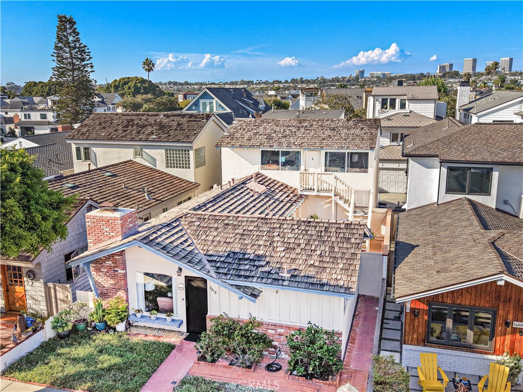 Aerial view of 2012 E Ocean Boulevard, with its shingle roof, brick chimney, and front garden.